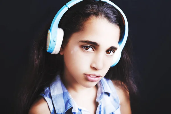 Афроамериканець дівчинка з навушниками, прослуховування музики на чорному фоні — стокове фото