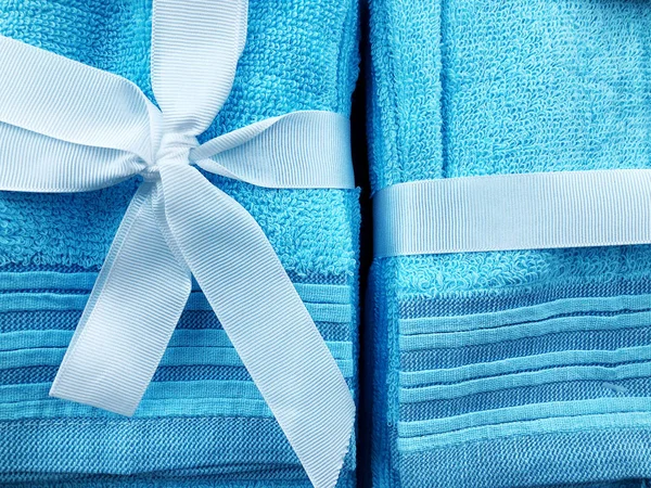 En blå handduk bunden av en blå båge kaak bakgrund för något. Dagsläget för kvinnor. — Stockfoto