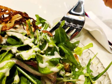 Marul üzerinden taze salata çeşitleri lahana havuç rucola Salata çeşitleri bırakır. Marul salatası için sos forks bırakır.