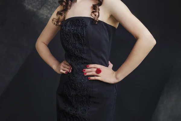Femme en robe noire avec un anneau rouge sur fond noir . — Photo