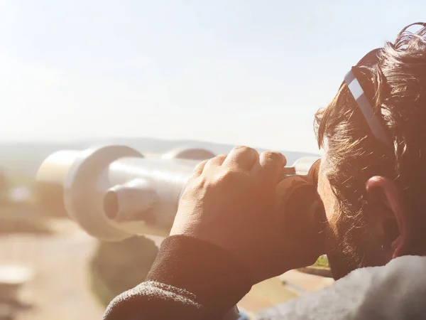 Touriste regarde dans le spectateur de tour jumelles à la vue sur la ville. Tower viewer est un appareil populaire pour regarder la ville — Photo