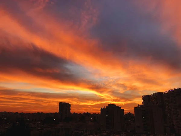 Günbatımı renkli sihirli bulutlar çarpıcı şehir. Bahar gökyüzü kırmızı bulutlar ve çatı Manzaralı. — Stok fotoğraf