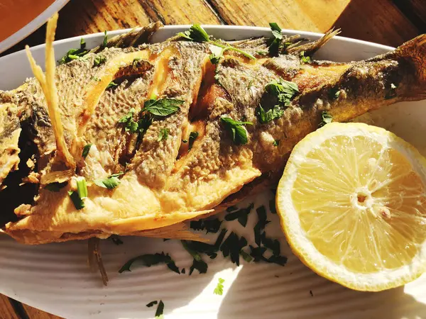 Bir restoranda bir plaka üzerinde ızgara balık lezzetli kızarmış. — Stok fotoğraf