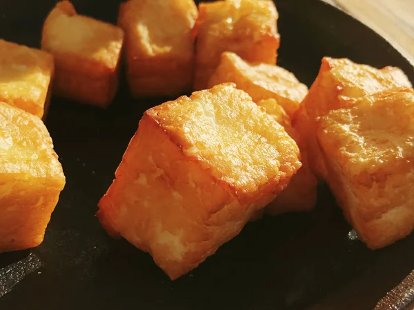 Köstlich gebratene Käsewürfel auf einem dunklen Teller. — Stockfoto
