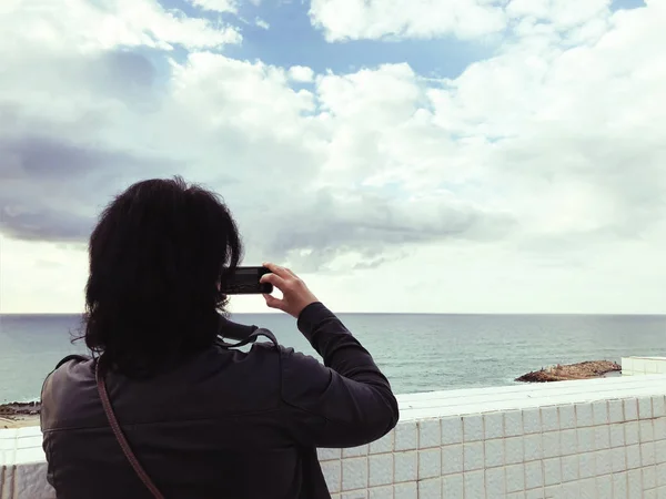 若い女の子は、海の美しい景色の写真を撮る — ストック写真