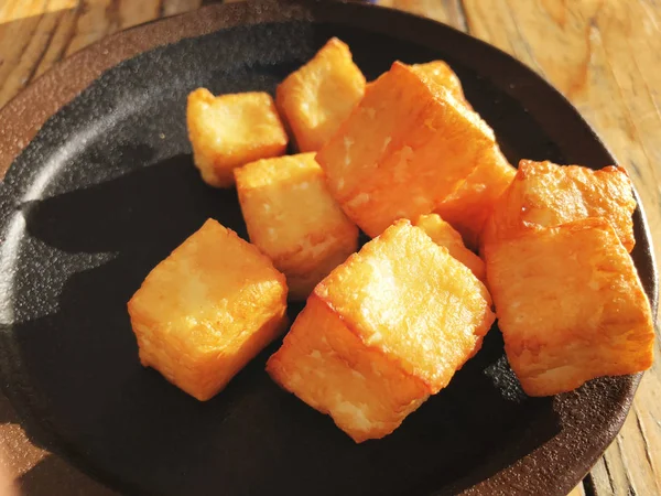 Deliciously fried cheese cubes on a dark plate. — Stock Photo, Image