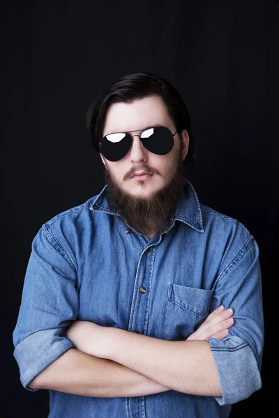 Retrato de um jovem barbudo posando sobre fundo preto — Fotografia de Stock