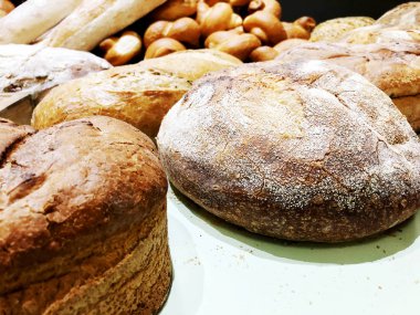 Bir sürü taze ekmek buns tablosundaki ile. Ekmek iş. Taze tahıl tohumları bir fırın ile buns. 