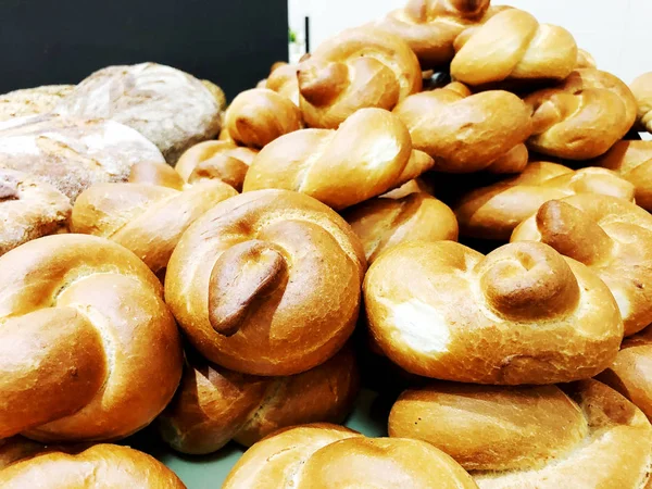 テーブルの上のパンと焼きたてのパンがたくさん。製パン事業。パン屋から種子を穀物から新鮮なパン. — ストック写真