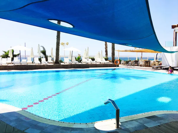 NAHARIYA, ISRAEL-MAY 19, 2017: Piscina grande de estilo moderno rodeada de sillones — Foto de Stock