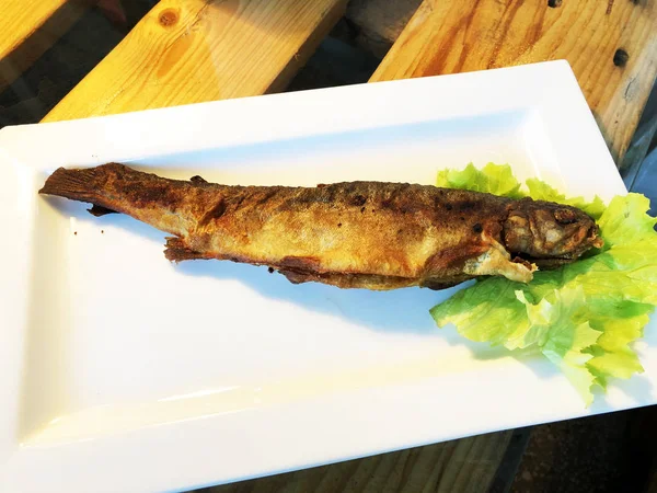 Ahşap masa üzerinde kızarmış balık. Gürcü mutfağı — Stok fotoğraf