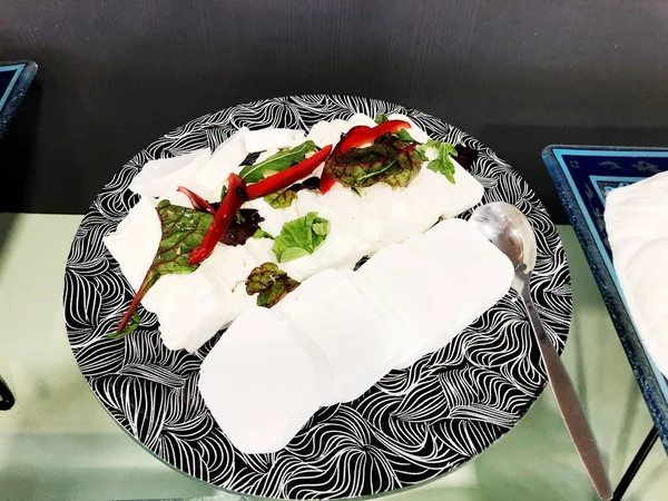 Rebanadas de queso blanco en un plato desgarrado con verduras y especias . —  Fotos de Stock