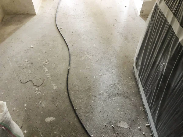 Kabel di lantai kotor. Bahan untuk perbaikan di sebuah apartemen sedang dalam pembangunan renovasi dan renovasi . — Stok Foto