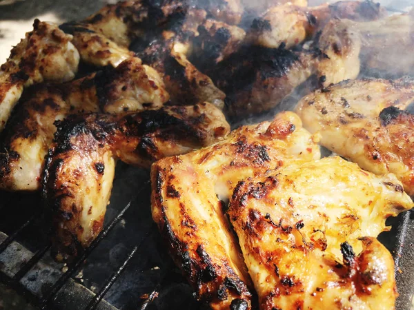 Жареная курица на гриле. Крупный план красного мяса и куриные ножки на гриле во время пикника — стоковое фото