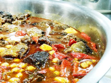 Patates ve sebze domates soslu bir tencerede pişirilmiş etli.