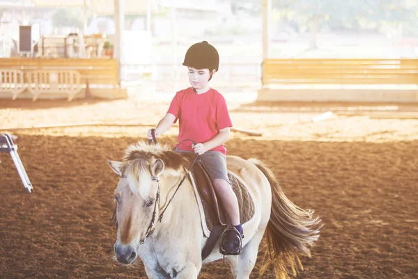 Un petit garçon monté à cheval. Premières leçons d'équitation — Photo