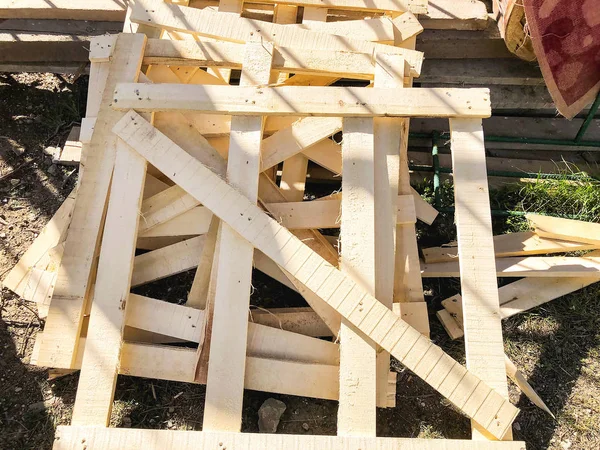木製パレットは、地上では建設現場で積み上げ。木製の背景イメージです。建設現場で地面に横たわって材料 — ストック写真