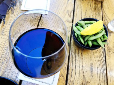 Şarap cam seçici odak hareket bulanıklık kırmızı bir bardak şarap. Bezelye ile şarap ve limon.