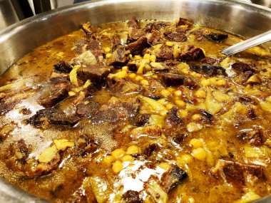 Patates ve sebze domates soslu bir tencerede pişirilmiş etli.