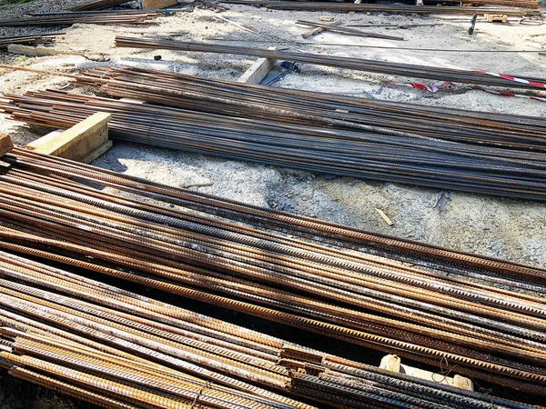 Logam, penguatan besi tergeletak di tanah di lokasi konstruksi. Bahan untuk perbaikan di sebuah apartemen sedang dalam pembangunan renovasi dan renovasi . — Stok Foto