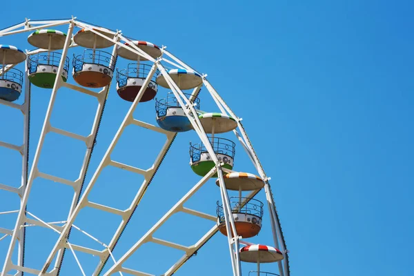 Kolorowy koło obserwacyjne na tle niebieskiego nieba w Luna Park. — Zdjęcie stockowe