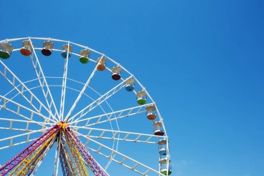Luna Park mavi gökyüzü arka plan üzerinde renkli dönme dolap.