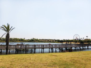 Rishon Le Zion, İsrail-14 Nisan 2018: insanlar yürüyüş boyunca Rishon Lezion, İsrail göle yakın bir ahşap yürüyüş köprü.