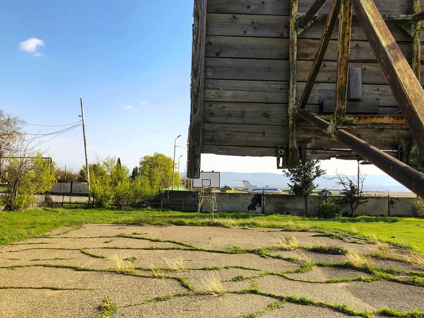 Basketball court in the school yeard, overgrown with grass. — Stock Photo, Image