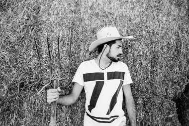 Yakışıklı sakallı genç kovboy pitch çatal tutan.