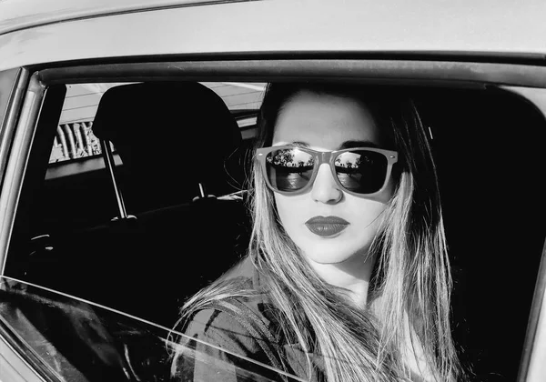 Schöne rothaarige Mädchen sitzt auf dem Rücksitz eines Autos. — Stockfoto