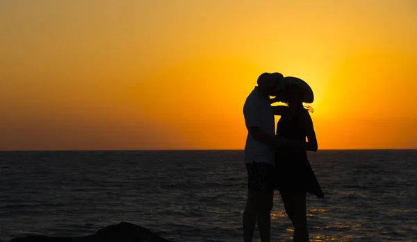 Silhouette di una coppia innamorata sulla spiaggia al tramonto.Storia d'amore.Uomo e donna sulla spiaggia . — Foto Stock