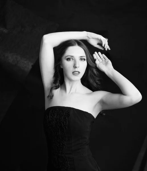 Porträt einer schönen Frau im schwarzen Kleid mit lockigem Haar - isoliert auf schwarzem Hintergrund — Stockfoto