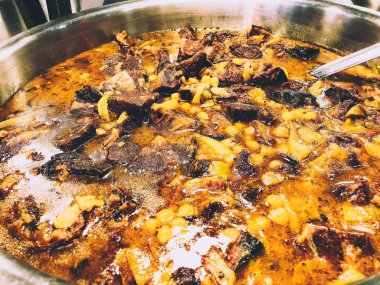 Patates ve sebze domates soslu bir tencerede pişirilmiş etli.