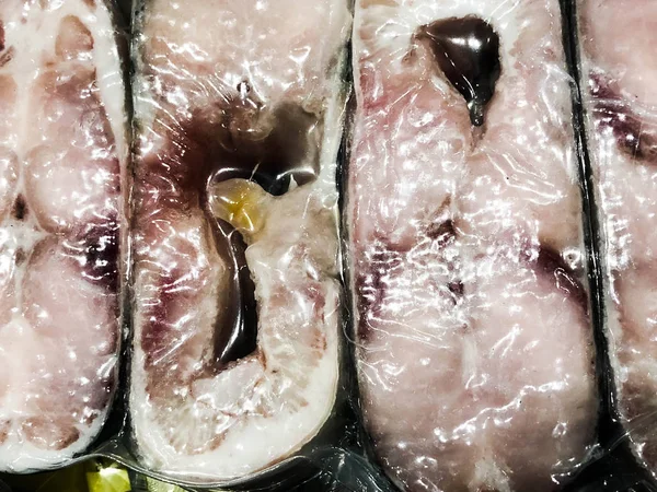 vacuum packed pieces of sturgeon in the store. Background closeup.