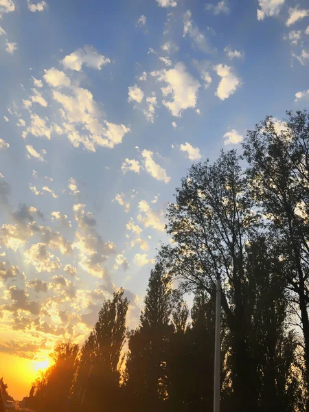 Céu nublado por sol com nuvens pitorescas iluminadas pela luz solar quente. Estrada rural ao pôr-do-sol — Fotografia de Stock