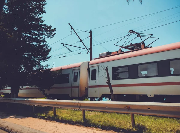 Seaside city, railway, moving passenger train on the railroad at summer day.  Industrial landscape. Transport — Stock Photo, Image