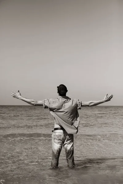Молодий м'язистий чоловік позує і стоїть з закрученими руками — стокове фото