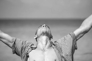 Genç kaslı adam poz veriyor ve elleri açık duruyor.