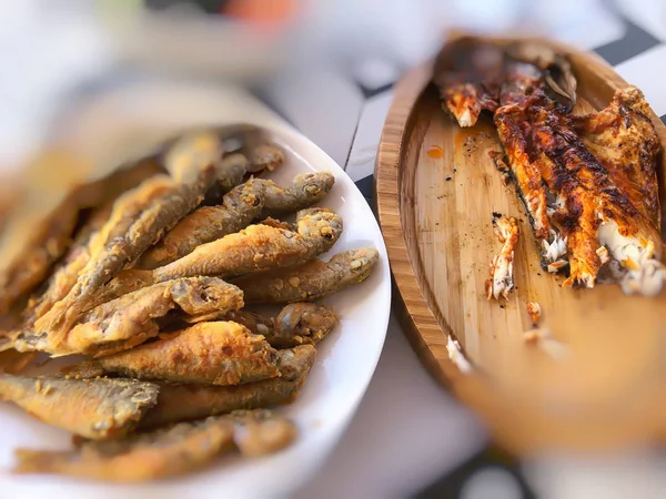 Two types of fried fish on wooden dishes. Blur effect — 图库照片