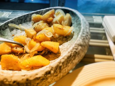 Tabakta kızarmış patates ve soğan.