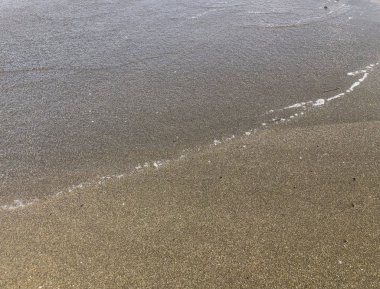 Kumsala yakın bir yerde. Yaz güneşli bir gün, su arka planı