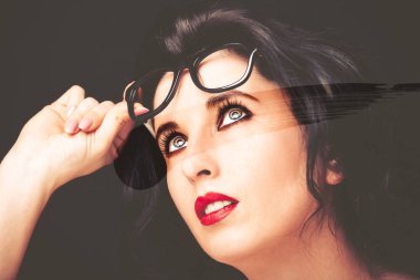 Uzun siyah saçlı, esmer, çekici bir kadın.