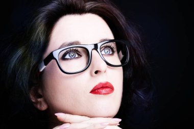 Uzun siyah saçlı, esmer, çekici bir kadın.