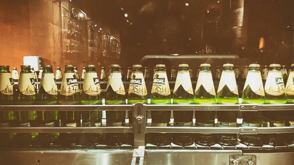 LVIV, UCRÂNIA - DEZEMBRO 7, 2019: Produção de cerveja. Linha de engarrafamento de bebidas. Garrafas de plástico na fábrica. Garrafas de cerveja transportadora . — Fotografia de Stock