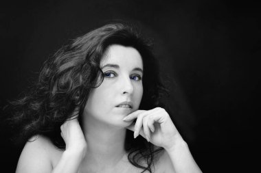 Uzun siyah saçlı, esmer, çekici bir kadın.