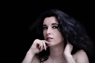 Uzun siyah saçlı, esmer, çekici bir kadın.