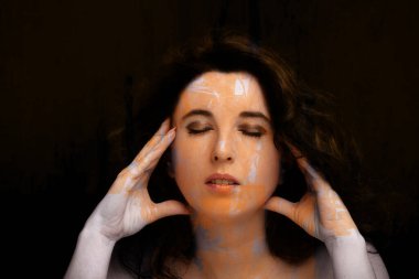 Uzun siyah saçlı, esmer, çekici bir kadın.