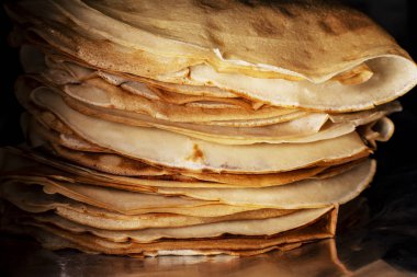 Siyah arkaplanda gözleme yığını. Yakın çekim.