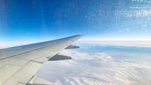 Η θέα από το αεροπλάνο στο τοπίο από το παράθυρο του αεροπλάνου. Πτέρυγα αεροπλάνου που πετάει πάνω από τα σύννεφα — Φωτογραφία Αρχείου