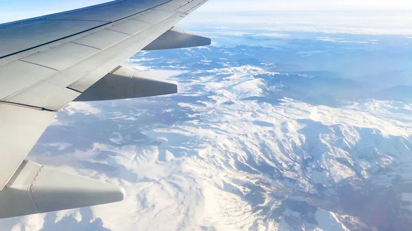 Η θέα από το αεροπλάνο στο τοπίο από το παράθυρο του αεροπλάνου. Πτέρυγα αεροπλάνου που πετάει πάνω από τα σύννεφα — Φωτογραφία Αρχείου